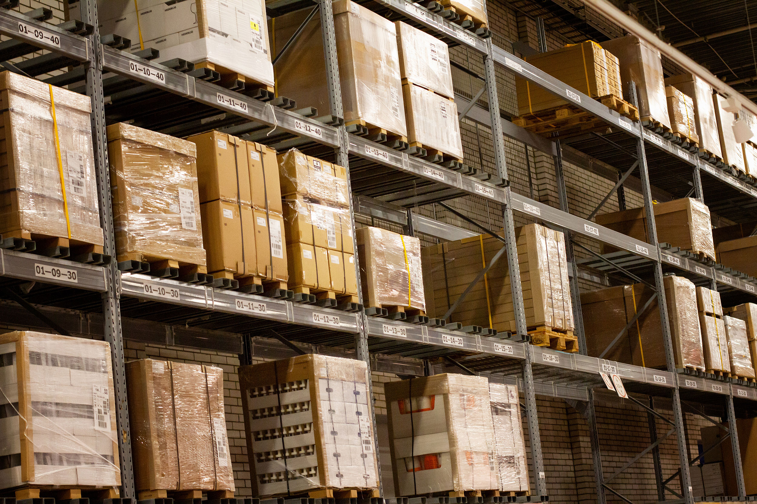 A warehouse with tall shelves filled with pallets and boxes