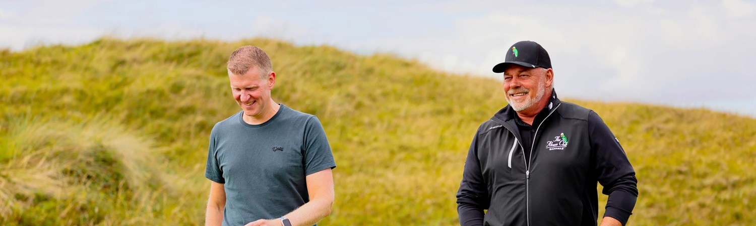 Golfer Darren Clarke talking with a friend on the golf course.