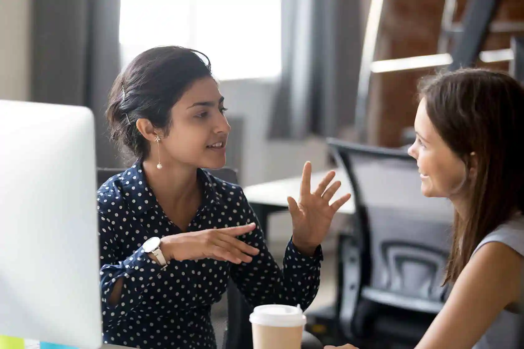 Two women talking over coffee