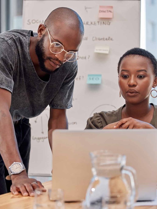 Two coworkers looking at a computer.