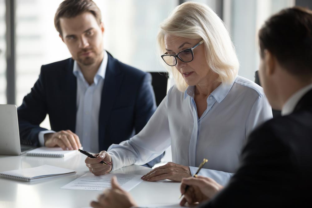 Three people review contracts