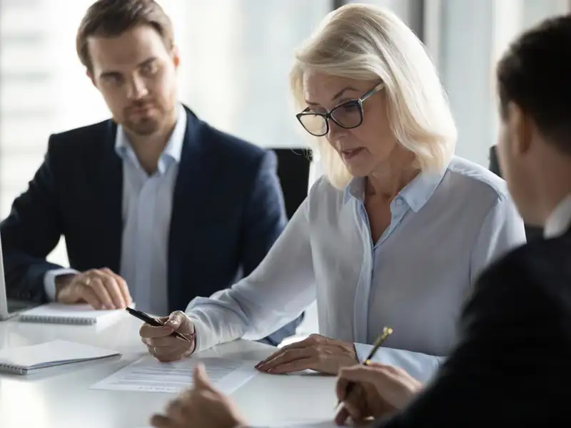 Three people review contracts